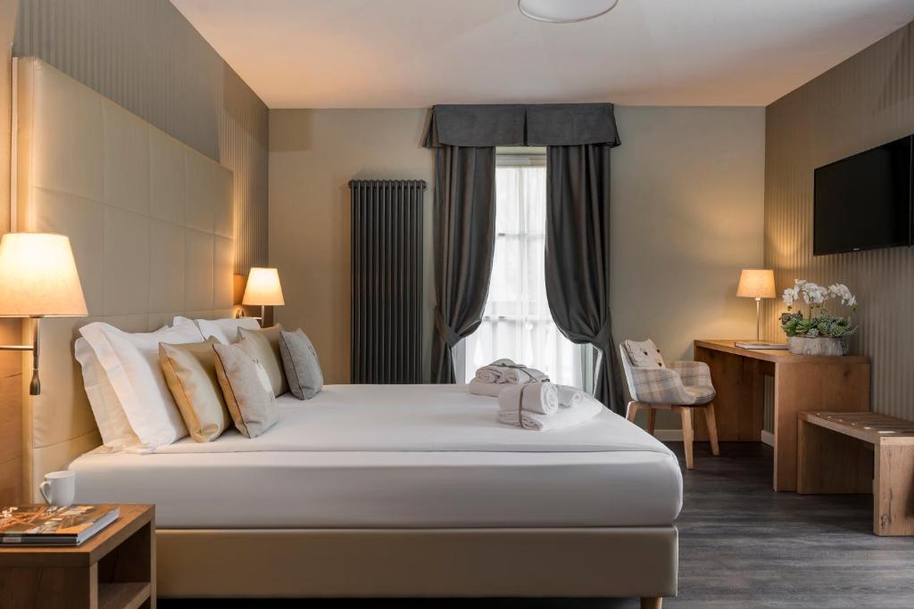 a hotel room with a bed and a window at X Alp Hotel in Pozza di Fassa