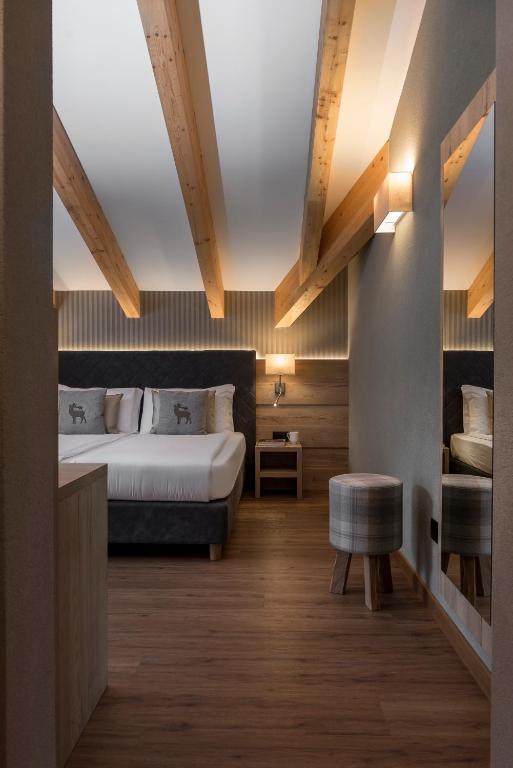 a hotel room with a bed and a chair at X Alp Hotel in Pozza di Fassa