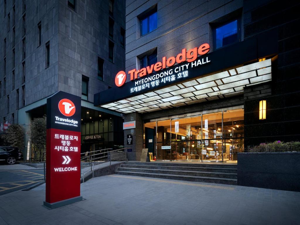 a large building with a sign in front of it at Travelodge Myeongdong City Hall in Seoul