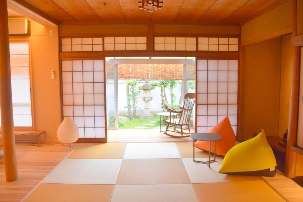 Zimmer mit Tür, Tisch und Stühlen in der Unterkunft Hiyorian - Vacation STAY 11234 in Takamatsu