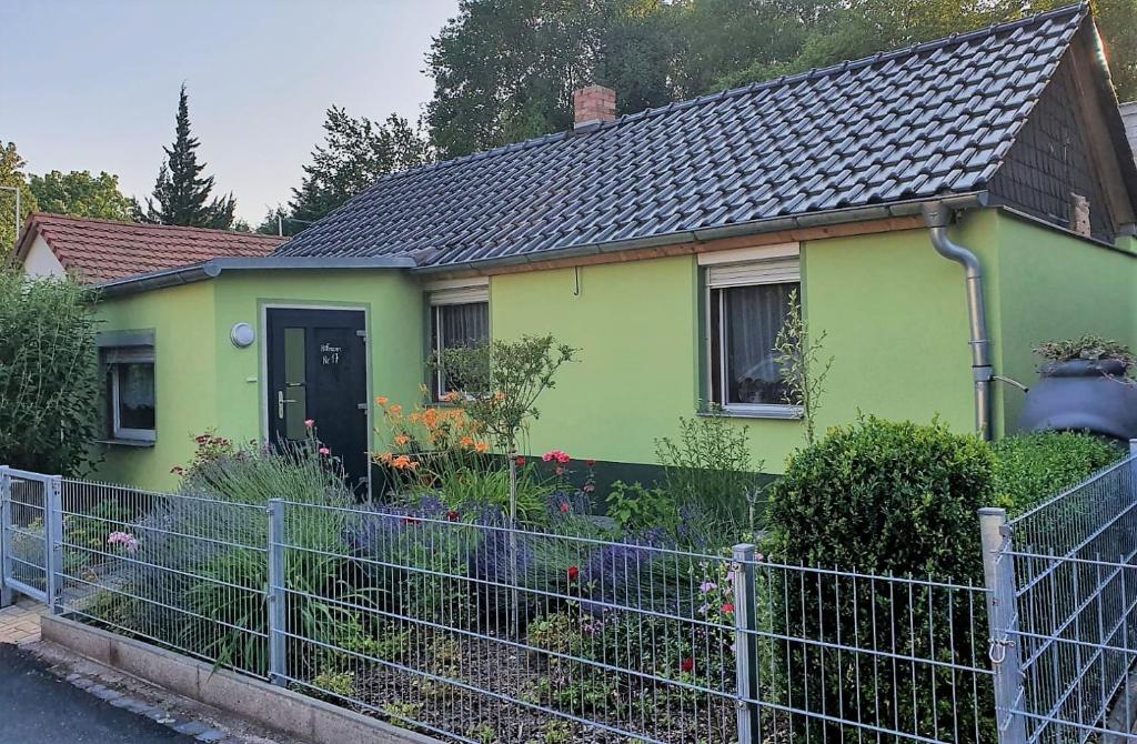 een groen huis met een hek ervoor bij Ferienhaus Hofmann in Lutherstadt Eisleben