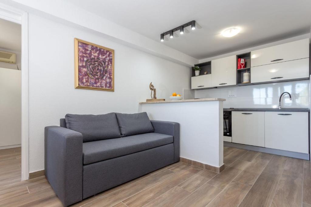 een woonkamer met een bank en een keuken bij NoMADS in Hvar