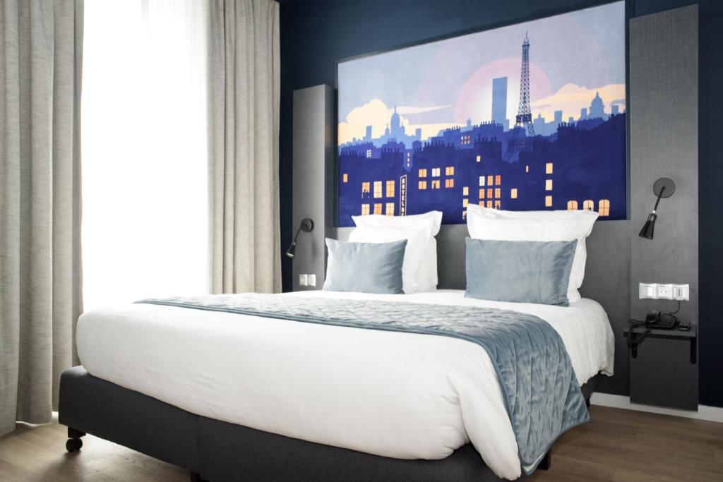 a bedroom with a large white bed with a city backdrop at Hôtel Des Arts-Bastille in Paris