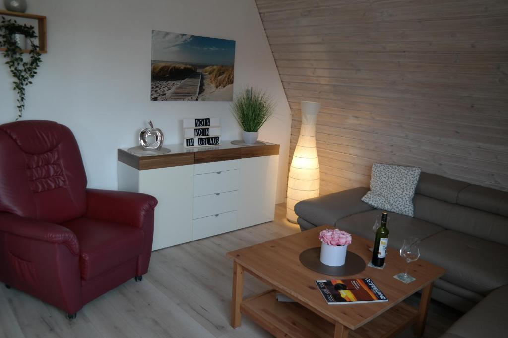 a living room with a couch and a chair and a table at Ferienhaus Knippschild in Norderney