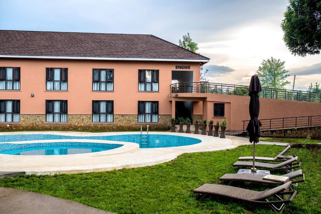 a hotel with a swimming pool in front of a building at Hunters Paradise Cottages in Bungoma