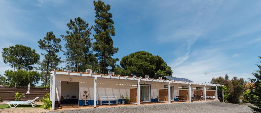 ein Haus mit einer Veranda mit Bäumen im Hintergrund in der Unterkunft MontePico in Grândola