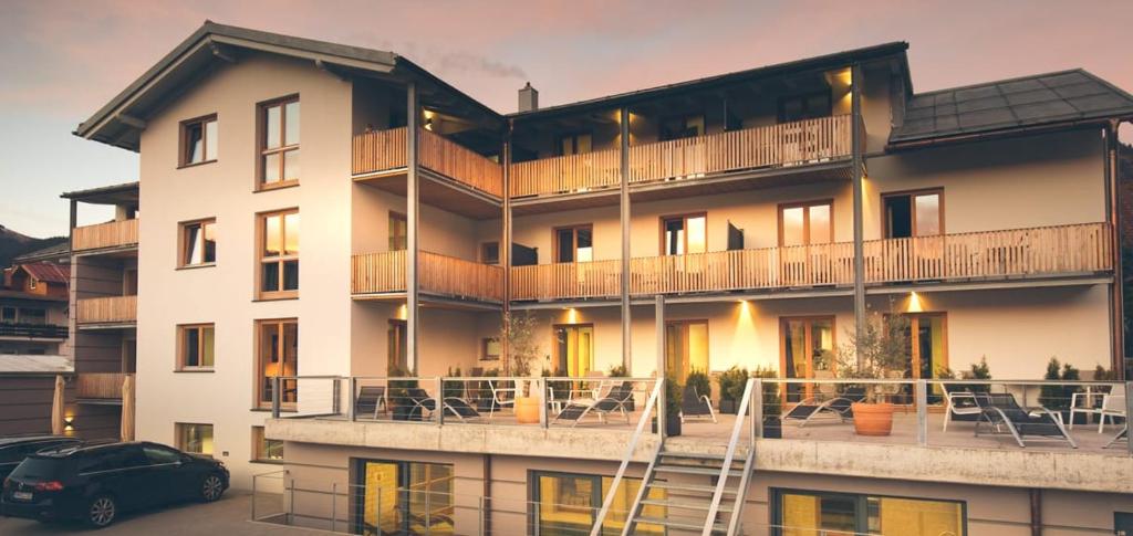 un grand bâtiment avec une voiture garée devant lui dans l'établissement Apartmenthotel Oberstdorf, à Oberstdorf