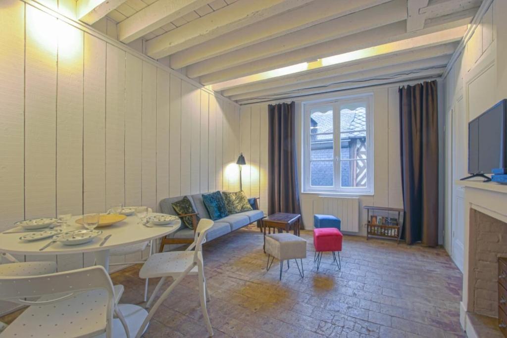 uma sala de estar com um sofá, uma mesa e cadeiras em 34 Notre Dame - PRETTY TRIPLEX HOUSE IN HONFLEUR-NEAR THE OLD PORT em Honfleur