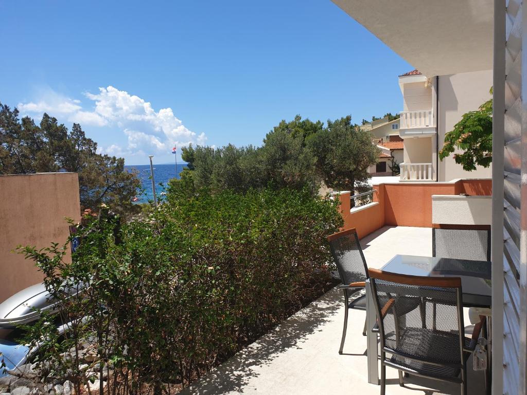 a balcony with a table and chairs and the ocean at Seaside Stay Rošić 2 in Ivan Dolac
