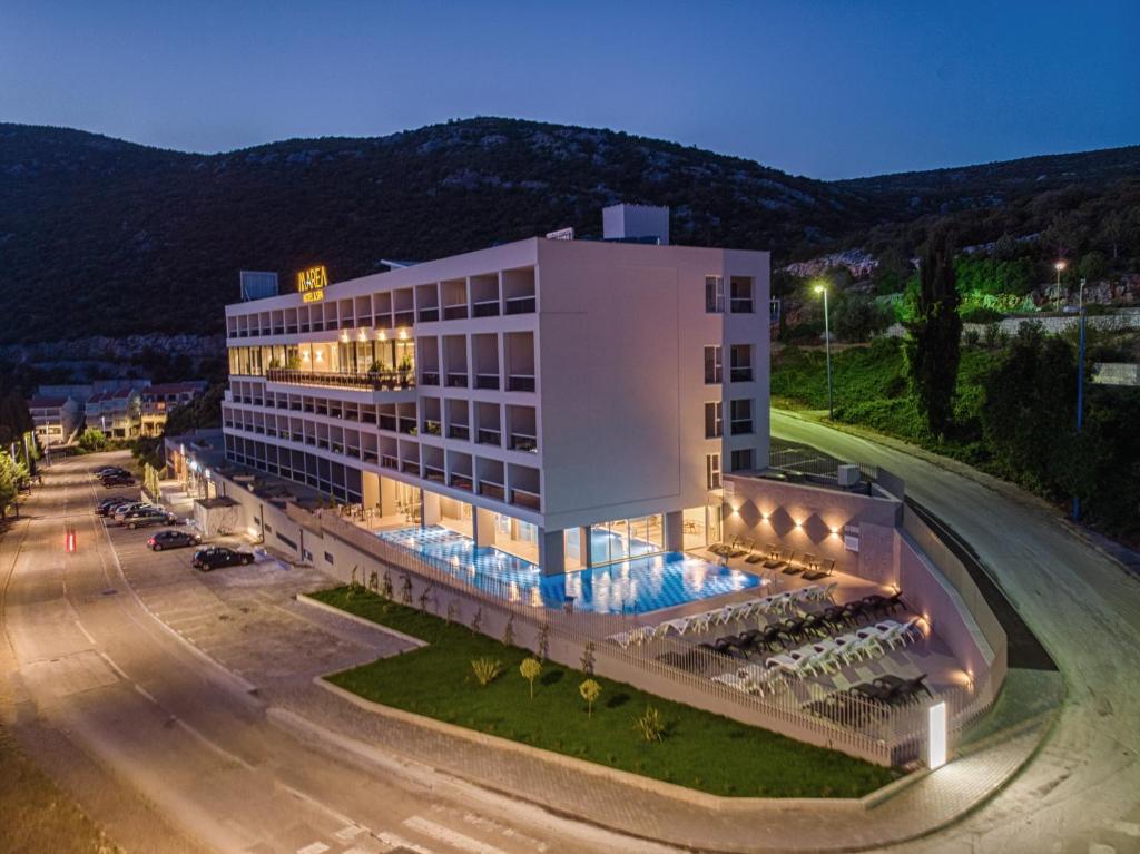 a large white building with a road in front of it at Marea Hotel & Spa in Neum