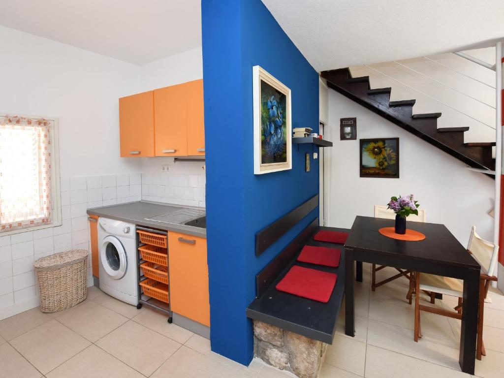 a kitchen with a table and a blue wall at Apartment Andrea Old Town Porec in Poreč