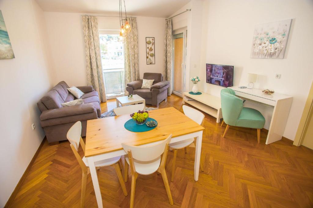 een woonkamer met een tafel en een eetkamer bij Apartman Dora in Poreč