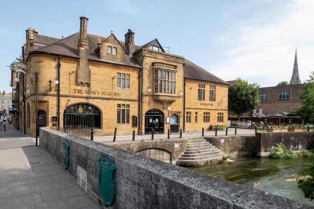 stary budynek obok rzeki z mostem w obiekcie The Kings Head Inn Wetherspoon w mieście Salisbury