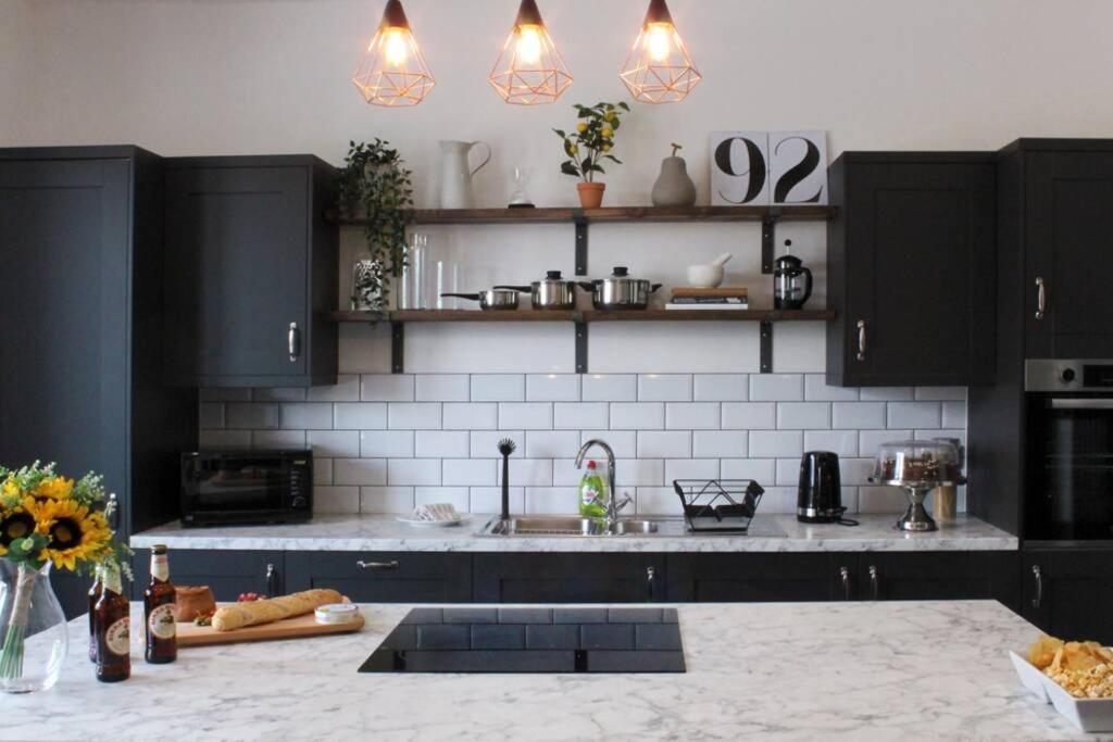 a kitchen with black cabinets and a counter top at StayWell Apt By Horizon Stays in Middlesbrough