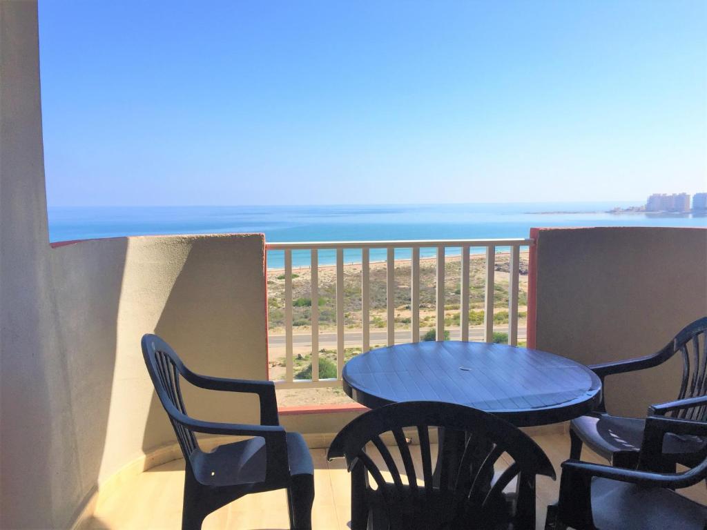 a table and chairs on a balcony with a view of the ocean at Spanish Connection - Seychelles in La Manga del Mar Menor