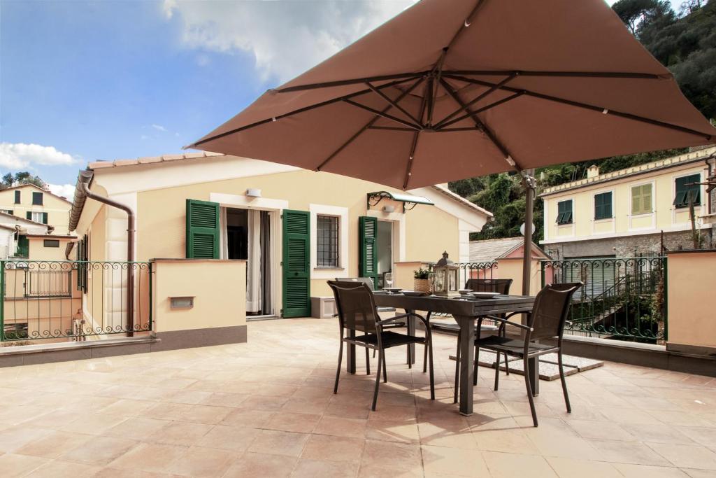 a patio with a table and chairs and an umbrella at Edone' by PortofinoHomes in Portofino