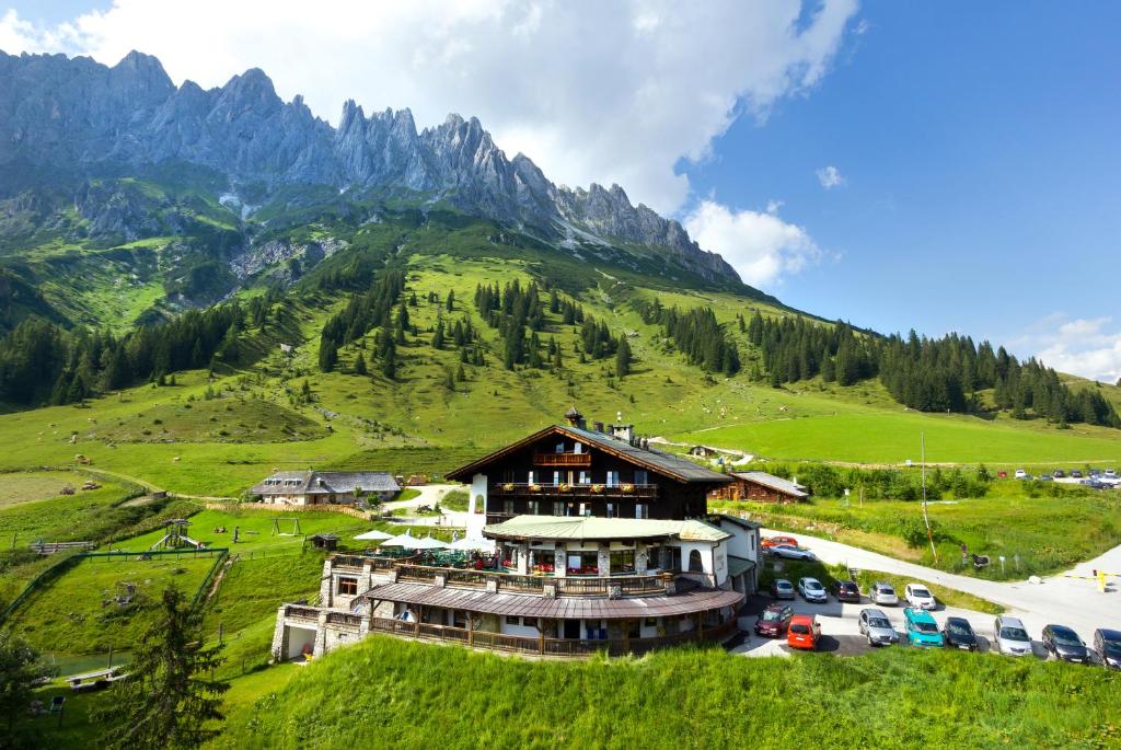 ein großes Gebäude auf einem Hügel mit einem Berg in der Unterkunft Berghotel Arthurhaus in Mühlbach am Hochkönig