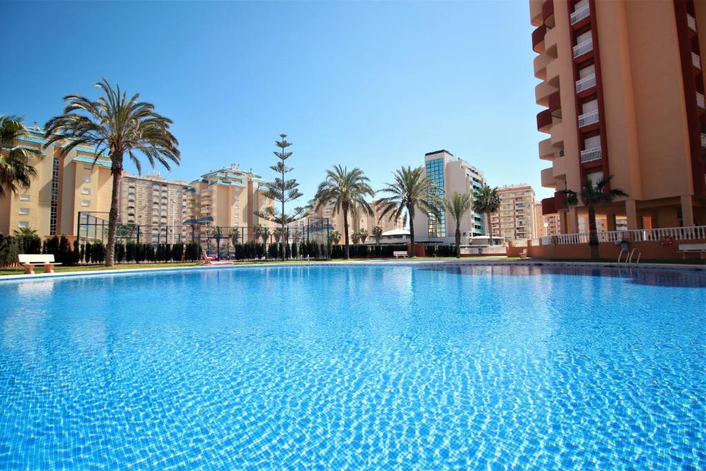 una gran piscina con palmeras y edificios en Spanish Connection - Los Miradores del Puerto en La Manga del Mar Menor