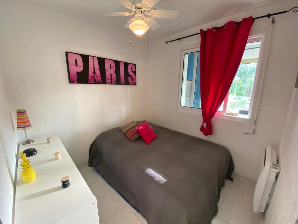 a bedroom with a bed and a red curtain at Boost Your Immo Six Fours Les Plages Pinèdes Aryana 477 in Six-Fours-les-Plages