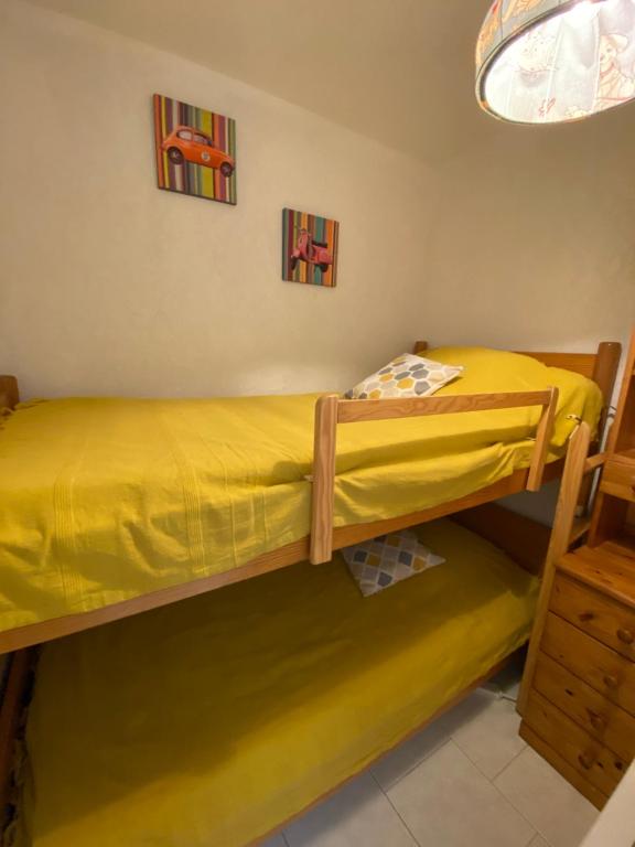 a bedroom with two bunk beds with yellow sheets at Boost Your Immo Six Fours Les Plages Pinèdes Aryana 477 in Six-Fours-les-Plages