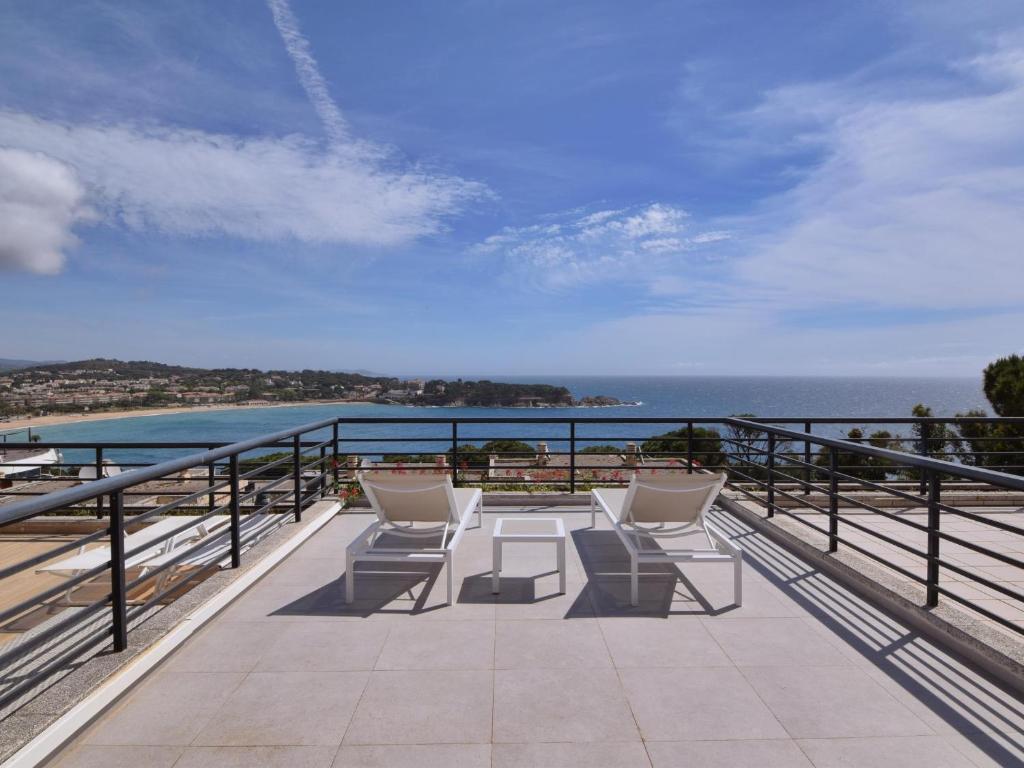 a balcony with chairs and a view of the ocean at Villa els ametllers in Sant Feliu de Guíxols