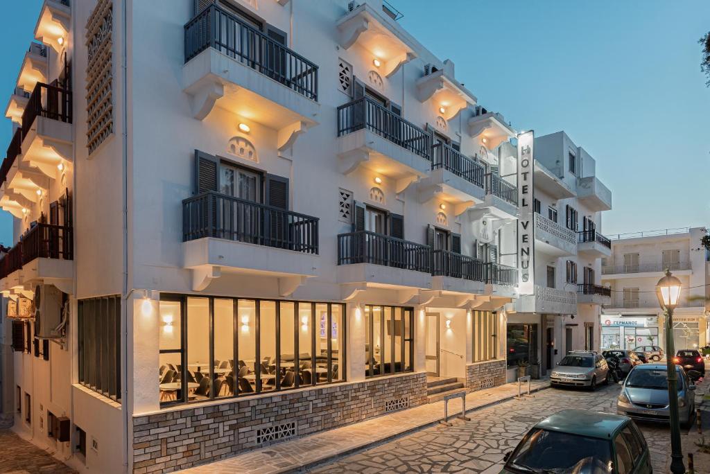 um grande edifício branco com janelas e uma rua em Venus Minimal Hotel em Tinos Town