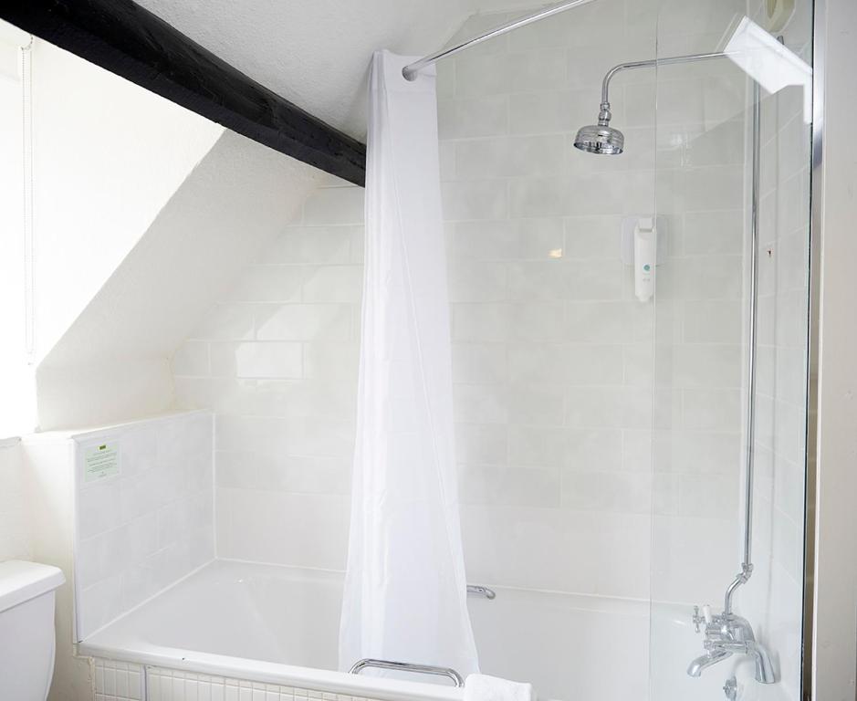 a white bathroom with a shower and a toilet at Old Manse Hotel by Greene King Inns in Bourton on the Water