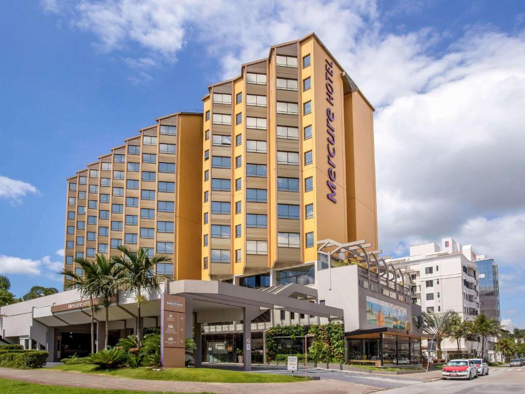 佛羅安那波里的住宿－Mercure Florianópolis，一座高大的黄色建筑,设有购物中心