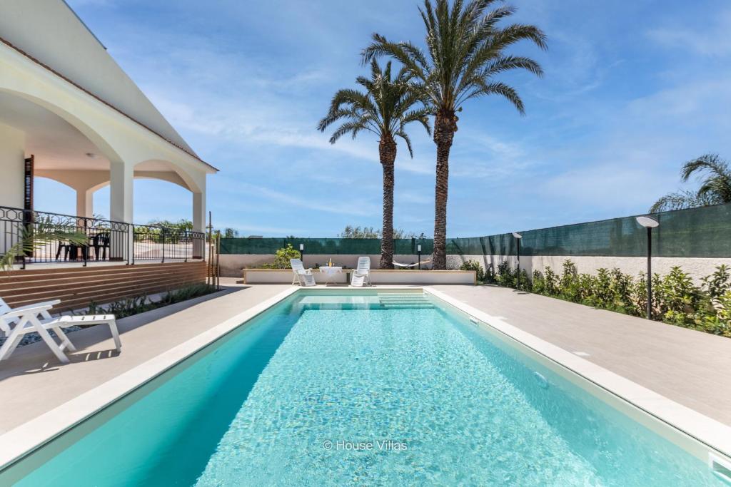 basen w ogrodzie domu z palmami w obiekcie House&Villas - Due Palme w Syrakuzach