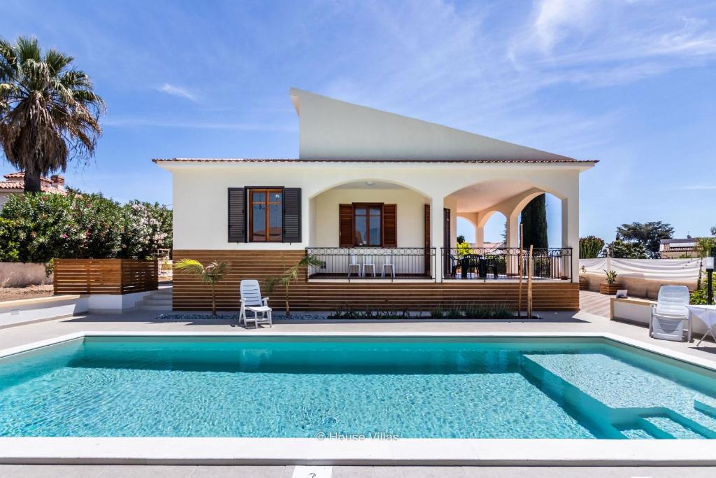 a house with a swimming pool in front of a house at House&Villas - Due Palme in Siracusa