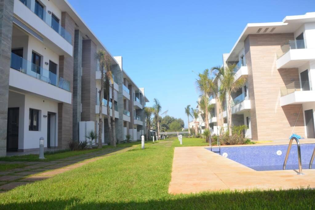 vista para um complexo de apartamentos com piscina em Appartement Residence Skhirat beach 2 em Skhirat