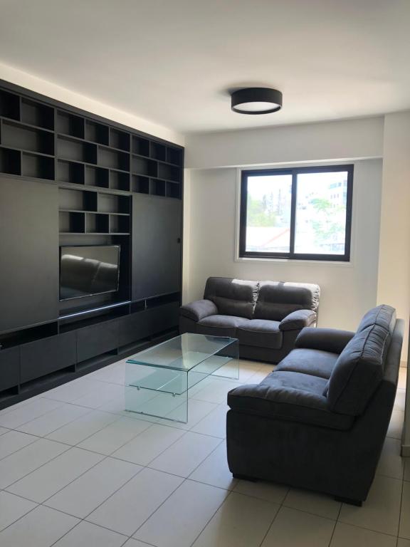 a living room with two couches and a tv at Modern Luxury Apartment in the heart of Nicosia in Nicosia