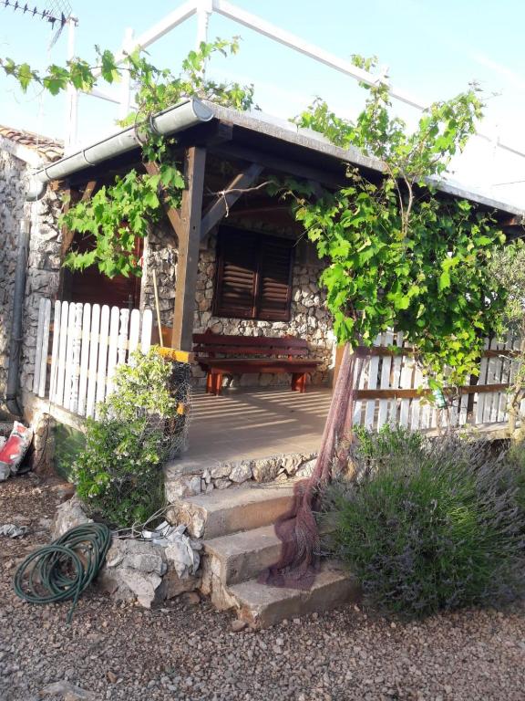 a small house with a wooden porch and a bench at Magunja in Neviđane