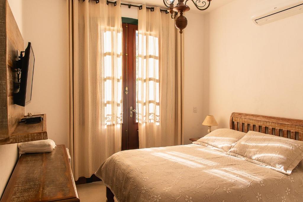 1 dormitorio con cama y ventana en Solar de Amelia, en Tiradentes