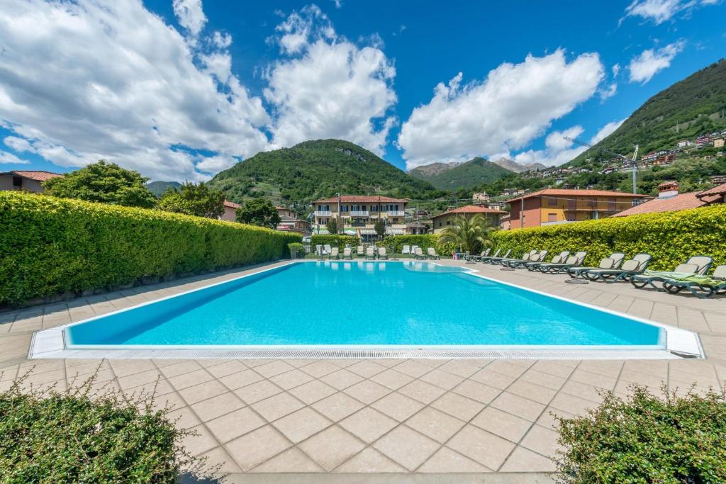 una piscina in un resort con montagne sullo sfondo di Bilocale a Domaso