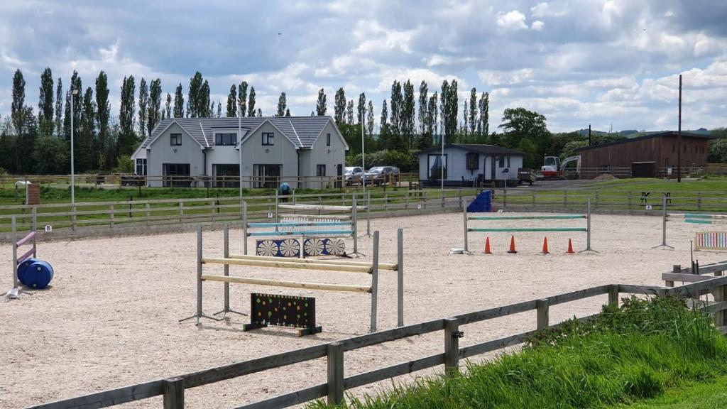 un parque infantil con pistas de voleibol en un campo en Huntersfield Chalet en Faringdon