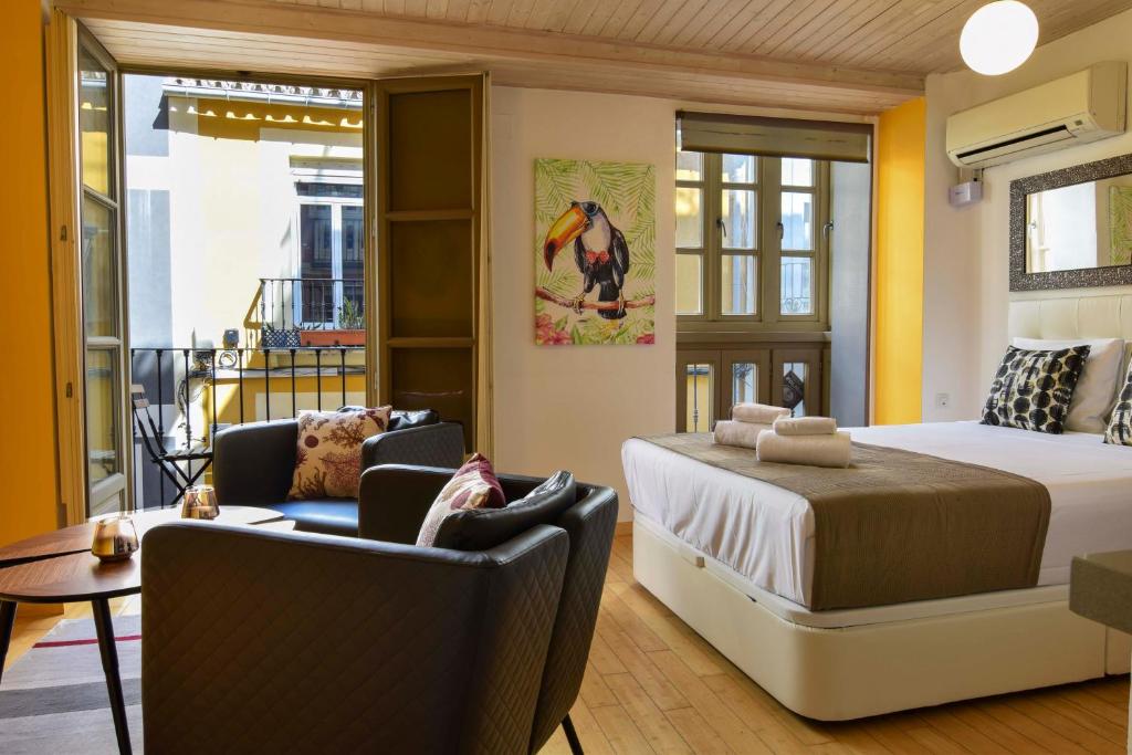 1 dormitorio con 1 cama y 2 sillas en una habitación en Letmalaga Lenid, en Málaga
