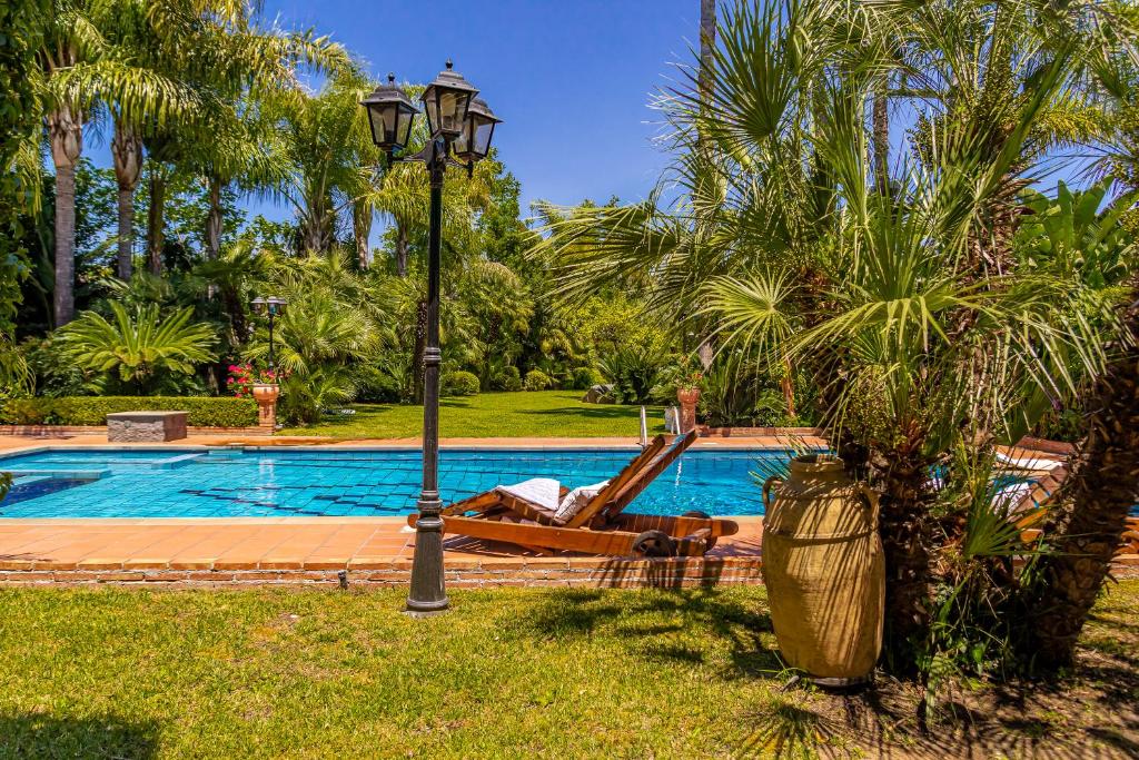 un hombre tendido en un sillón junto a una piscina en Villa Gialla, en Aci Catena