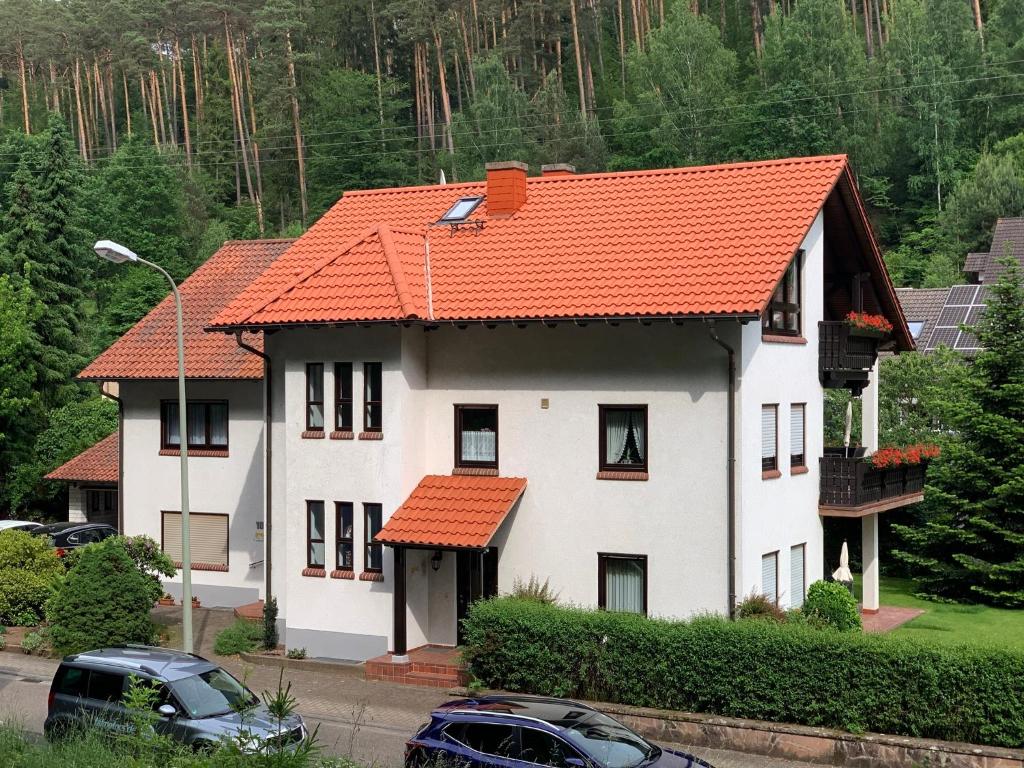 a large white house with an orange roof at Ferienwohnungen im Herzen des Pfälzerwaldes in Elmstein