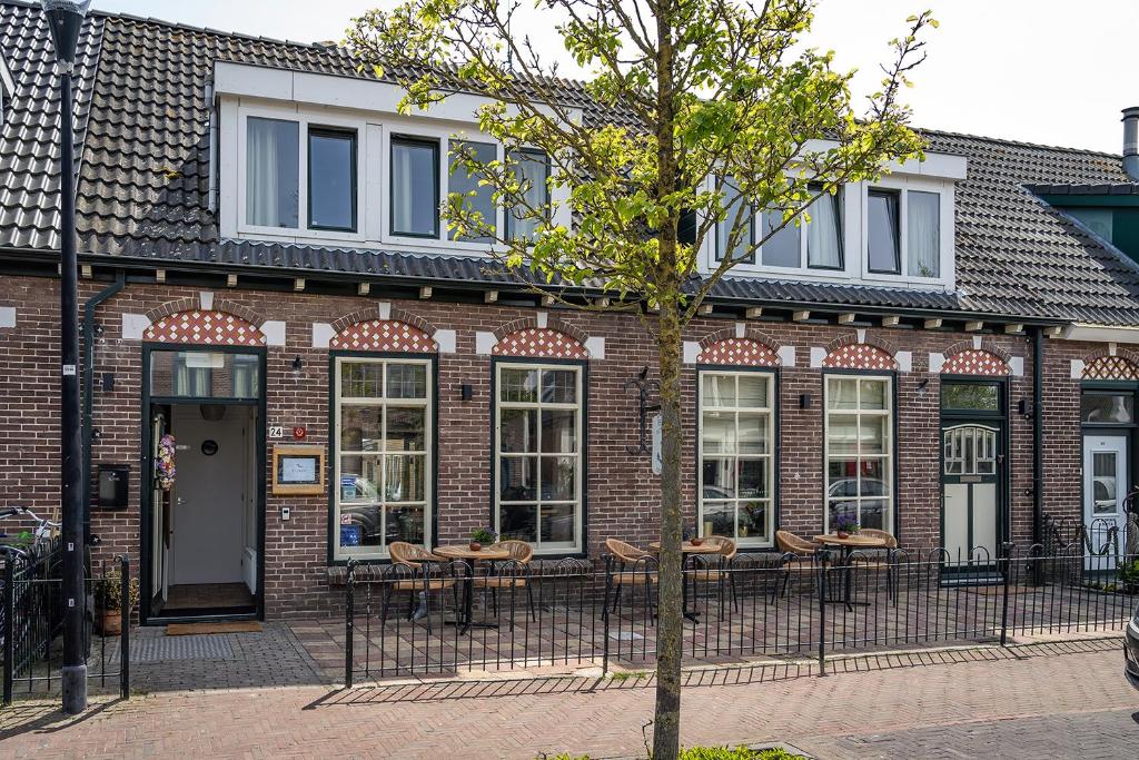 un bâtiment en briques avec des tables et des chaises devant lui dans l'établissement Hotel het Anker van Texel, à De Cocksdorp