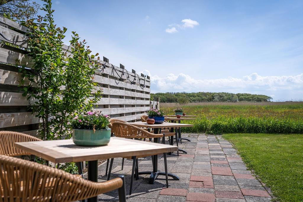 a row of tables and chairs on a patio at Hotel het Anker van Texel in De Cocksdorp