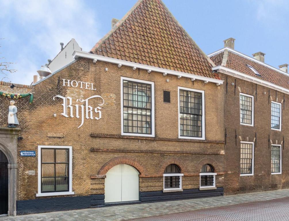 Boutique Hotel Rijks I Kloeg Collection في خوس: مبنى من الطوب مكتوب عليه كلمة فندق يضرب