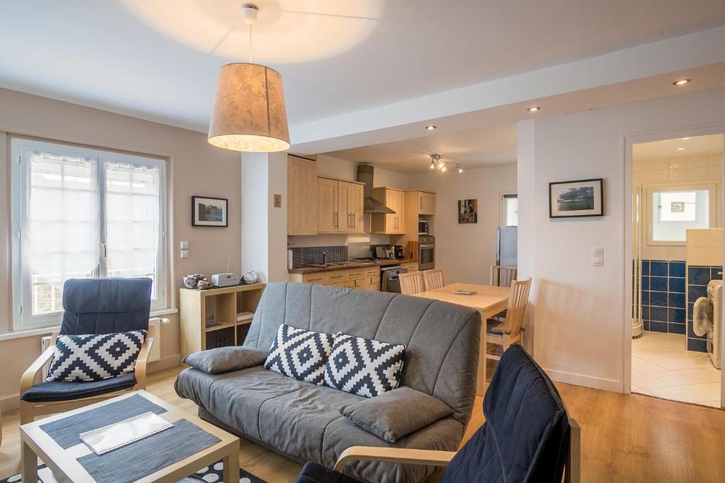 a living room with a couch and a kitchen at Le Sainte Anne in Saint Malo