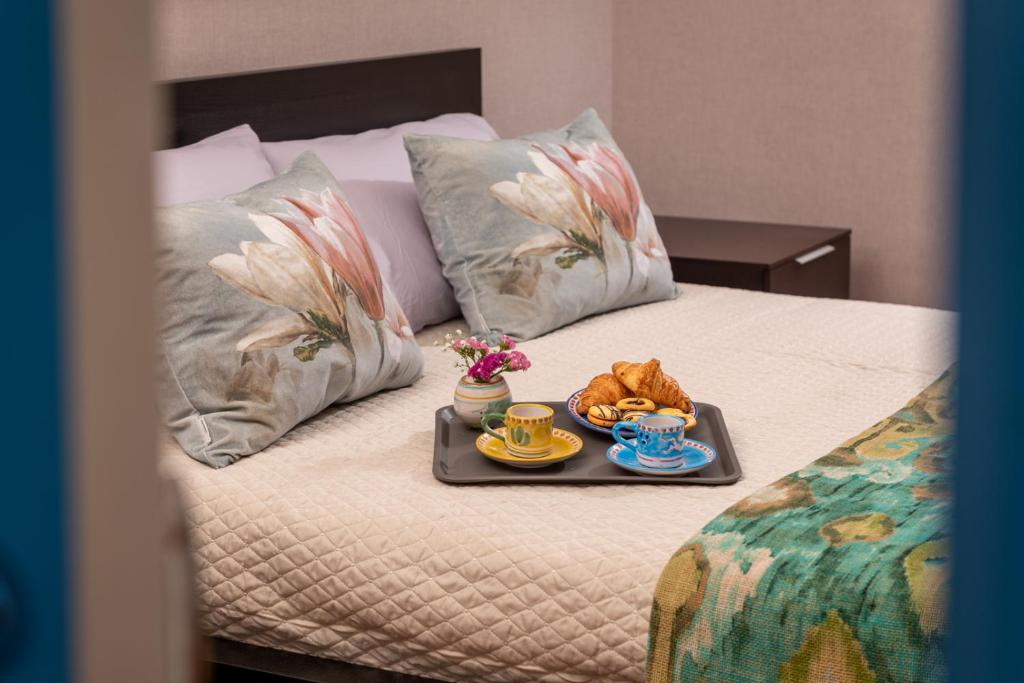 a tray of food and drinks on a bed at Suitesettepesciolini - Casa vacanza PERLA in Salerno