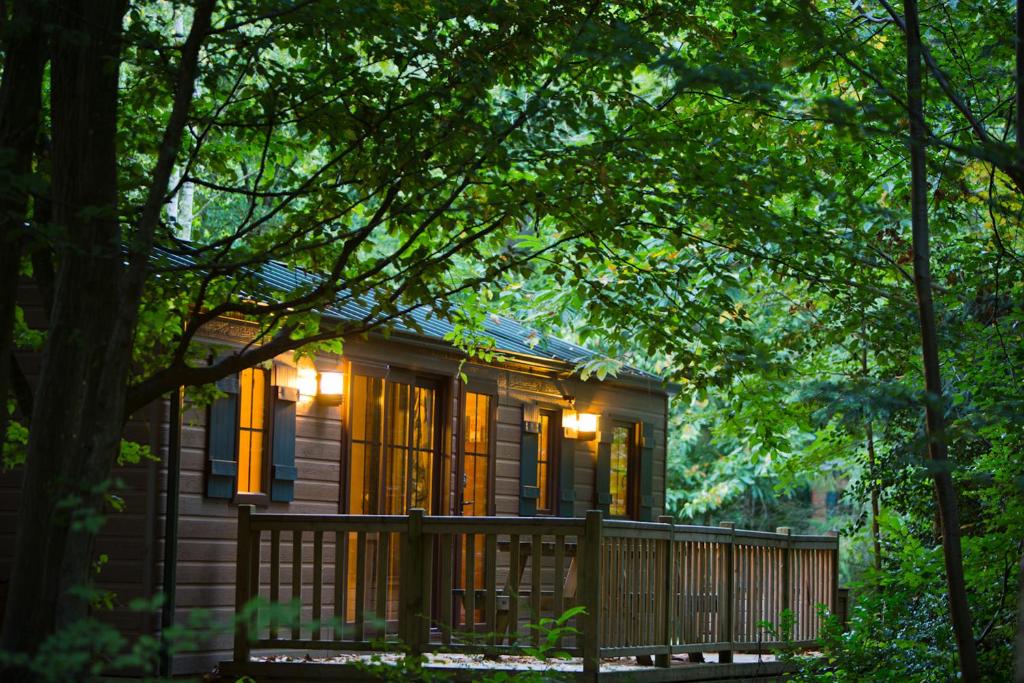 una pequeña casa de madera con una valla y árboles en Disney Davy Crockett Ranch, en Villeneuve-le-Comte