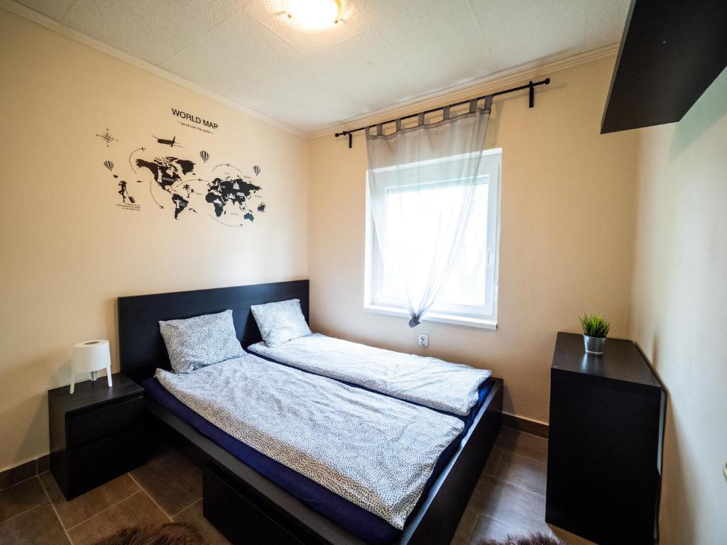 a bedroom with a bed and a window at Liget Holiday Home in Fonyód