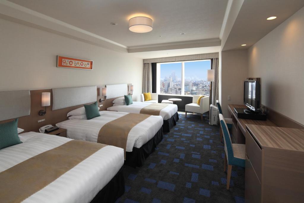 a hotel room with four beds and a television at Shibuya Excel Hotel Tokyu in Tokyo