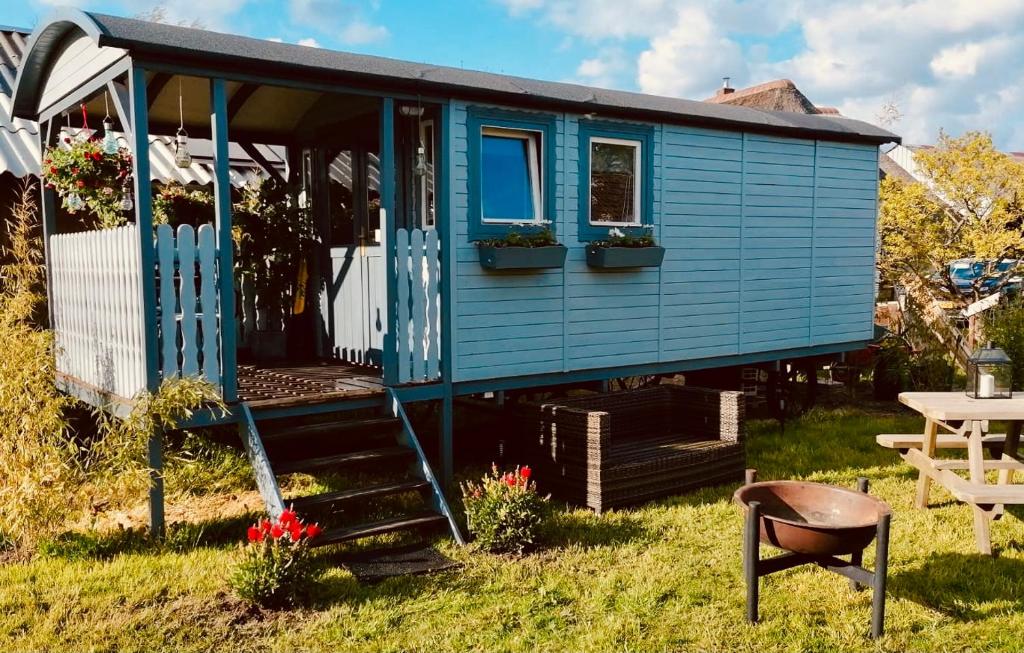 a blue tiny house with a table and a chair at Pipowagen Mammaloe in Wijhe