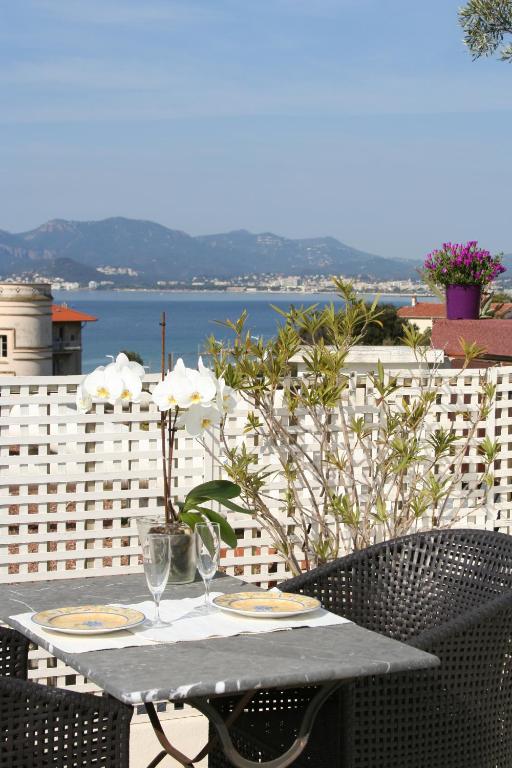 une table avec deux verres à vin sur un balcon dans l'établissement Esterel Terrasses, roof top, plage, parking payant, à Cannes