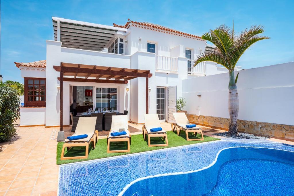 a villa with a swimming pool and a house at Casa Piscis in Adeje